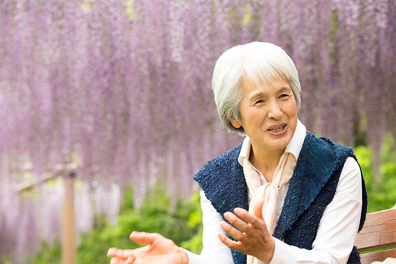 Конамі Цукамото розмовляє під гліциніями в Парку квітів Хамамацу